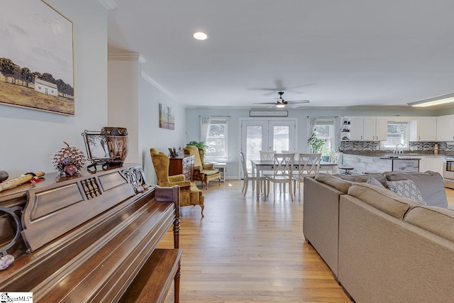 living room featuring light wood finished floors, recessed lighting, a ceiling fan, and ornamental molding