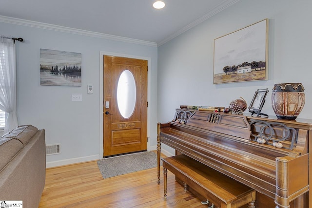 entrance foyer with visible vents, plenty of natural light, light wood-type flooring, and crown molding