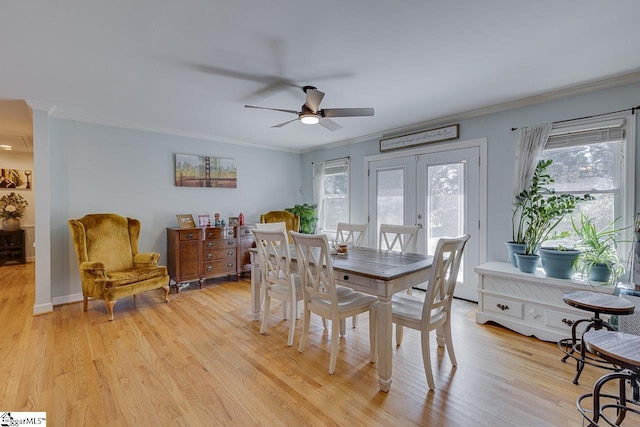 dining room featuring french doors, light wood-style flooring, and crown molding