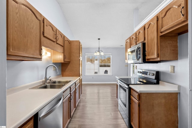 kitchen featuring light countertops, an inviting chandelier, wood finished floors, stainless steel appliances, and a sink