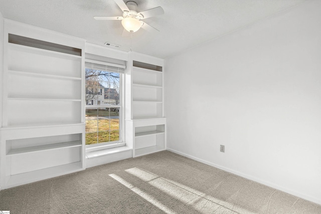 unfurnished room with visible vents, ceiling fan, baseboards, carpet, and a textured ceiling