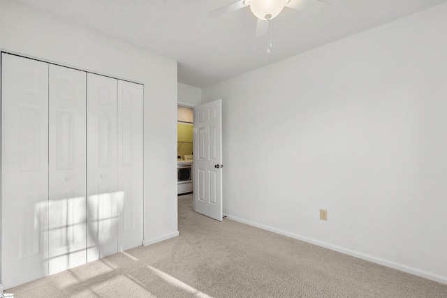 unfurnished bedroom with a ceiling fan, washer / clothes dryer, a closet, carpet flooring, and baseboards