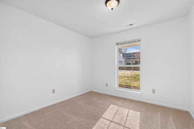 spare room featuring visible vents, baseboards, and carpet