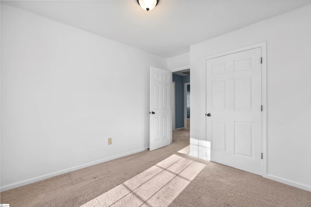 unfurnished bedroom featuring carpet flooring and baseboards