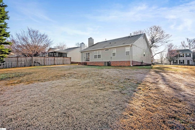 back of property with cooling unit, a chimney, and fence