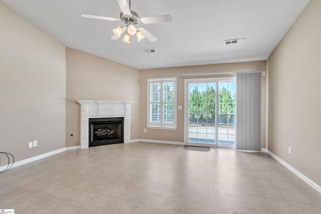 unfurnished living room with visible vents, ceiling fan, a fireplace, and baseboards