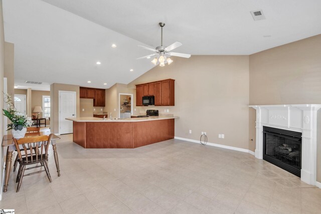 kitchen with brown cabinetry, visible vents, a peninsula, black appliances, and light countertops