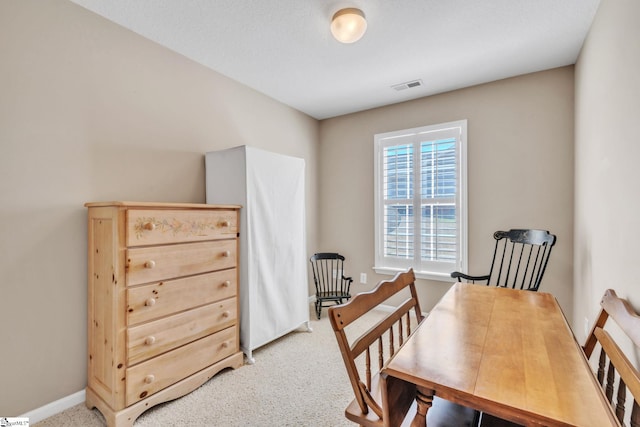 office space with visible vents, light carpet, and baseboards