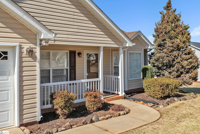 property entrance with covered porch and an attached garage