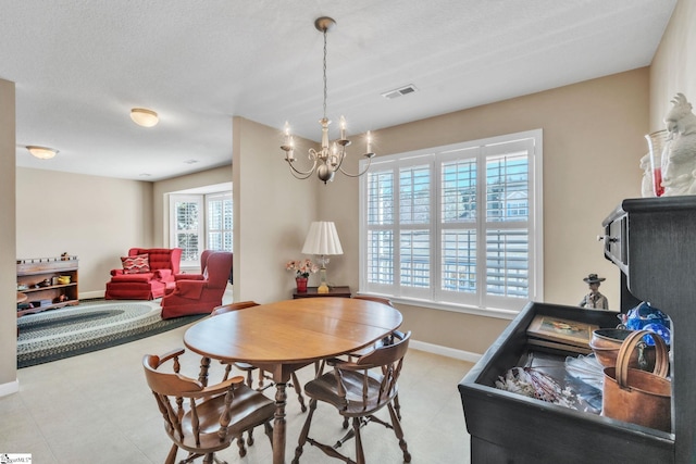 dining area featuring a notable chandelier, visible vents, and baseboards