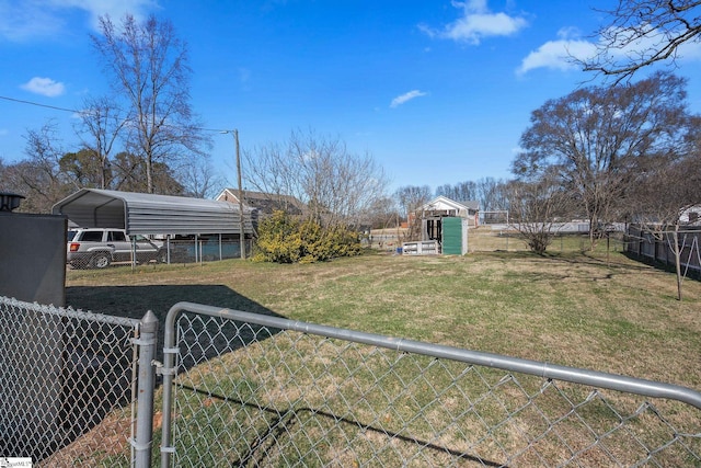 view of yard with a carport, an outdoor structure, and fence