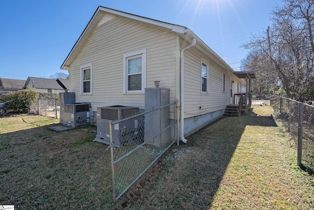 back of house featuring a lawn, central AC unit, and fence