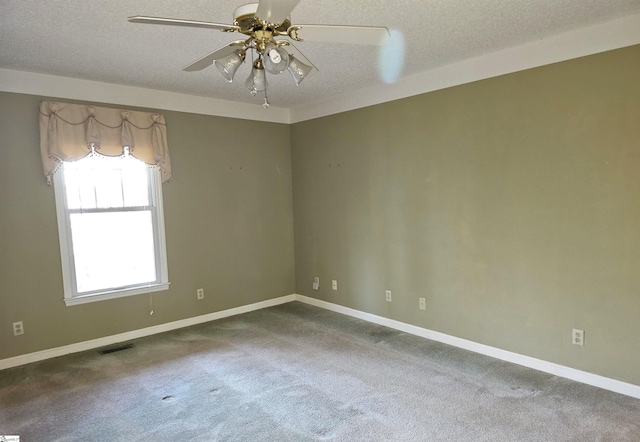 spare room with visible vents, baseboards, ceiling fan, a textured ceiling, and dark colored carpet