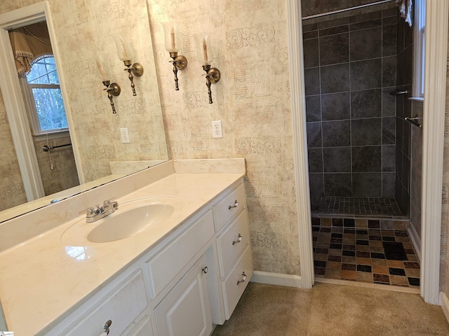 bathroom featuring a tile shower and vanity