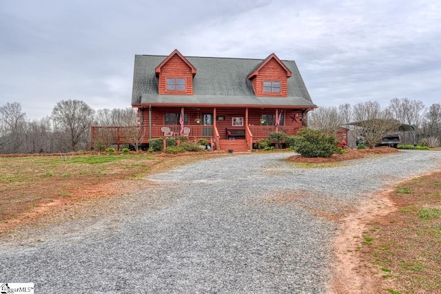 log home featuring covered porch and driveway