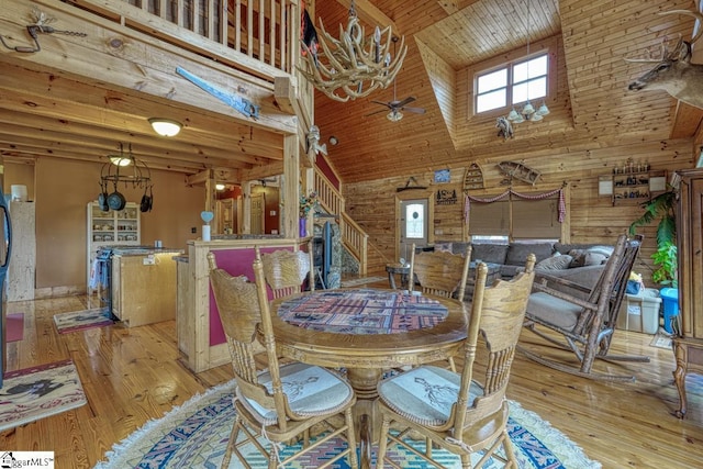 dining space featuring wooden ceiling, light wood-style flooring, a ceiling fan, and high vaulted ceiling