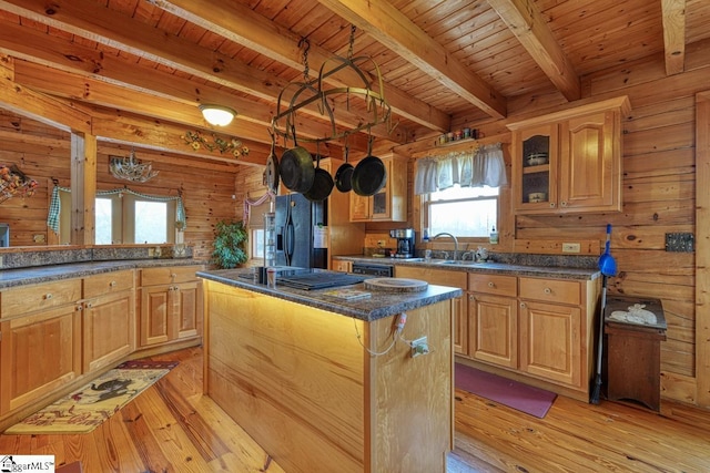 kitchen with black appliances, light wood-style flooring, wood ceiling, and a center island