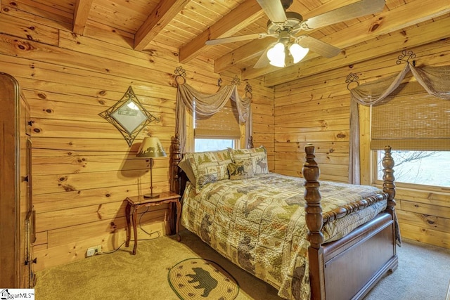 carpeted bedroom featuring beam ceiling, wooden walls, wood ceiling, and ceiling fan