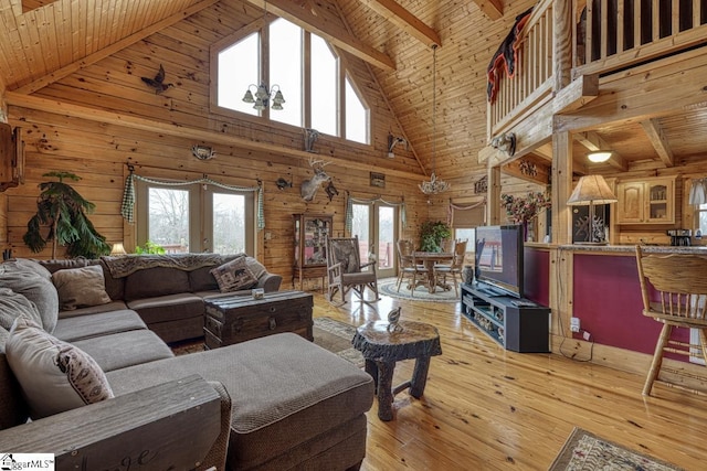 living room with wooden ceiling, light wood finished floors, french doors, and wood walls