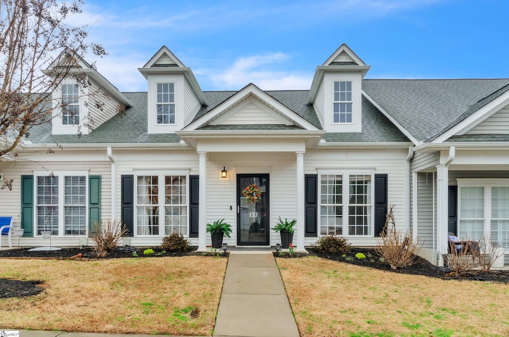 view of front of property with a front yard and roof with shingles