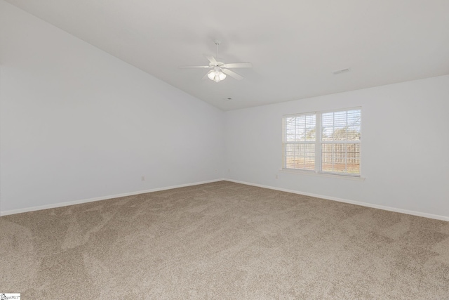 carpeted spare room featuring vaulted ceiling, baseboards, and ceiling fan