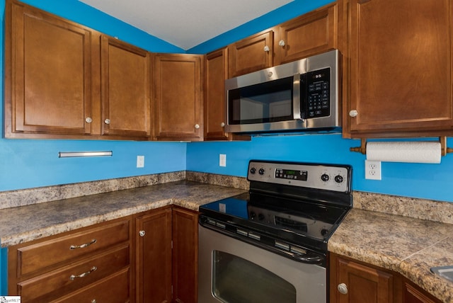 kitchen featuring stainless steel appliances and brown cabinets