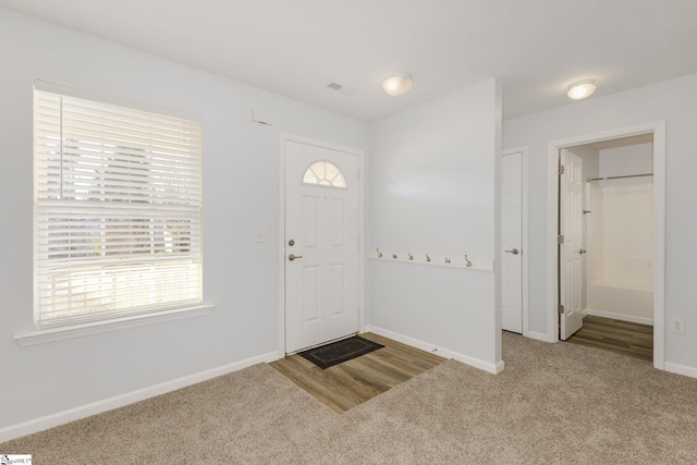 carpeted foyer entrance featuring visible vents and baseboards