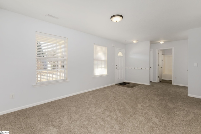 foyer entrance with visible vents, baseboards, and carpet floors