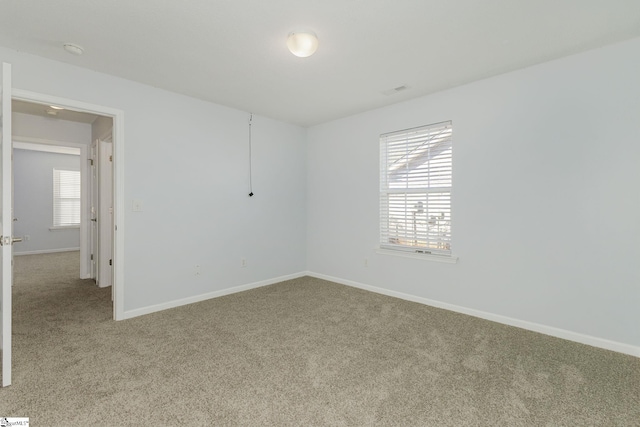 unfurnished room with baseboards and carpet