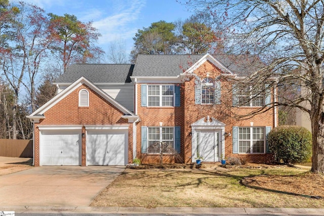 colonial-style house with brick siding, concrete driveway, an attached garage, and fence