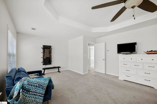 sitting room with a tray ceiling, baseboards, light colored carpet, and visible vents