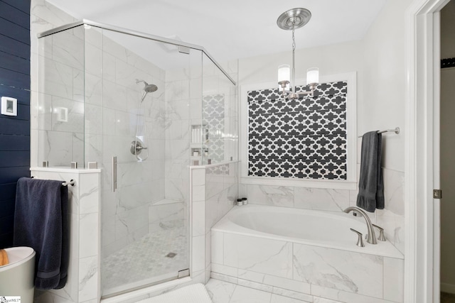 bathroom featuring an inviting chandelier, marble finish floor, a stall shower, and a bath