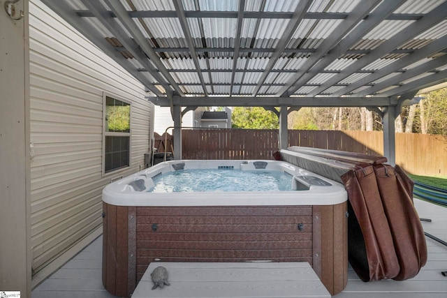 wooden deck featuring a hot tub and fence