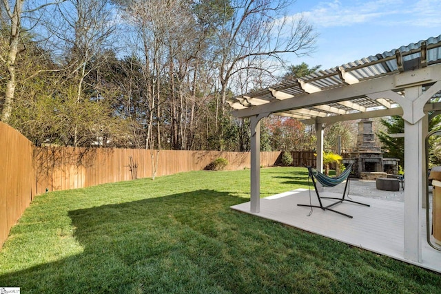 view of yard with a fenced backyard, a pergola, and an outdoor stone fireplace