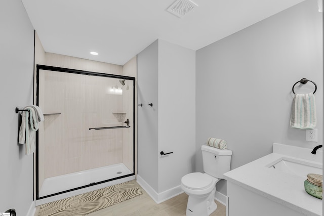 full bathroom with visible vents, toilet, a tile shower, baseboards, and vanity