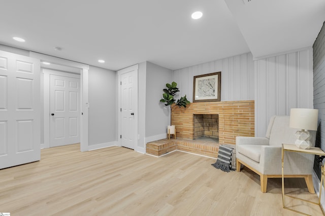 sitting room with recessed lighting, light wood-style flooring, a fireplace, and baseboards