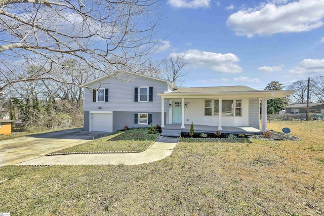 split level home featuring brick siding, a porch, concrete driveway, a front yard, and an attached garage