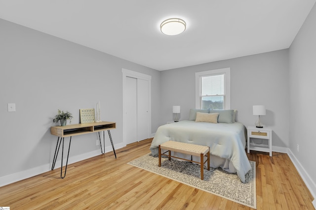 bedroom featuring a closet, baseboards, and wood finished floors