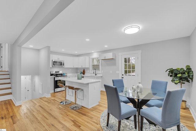 dining space with recessed lighting, stairway, baseboards, and light wood-style flooring