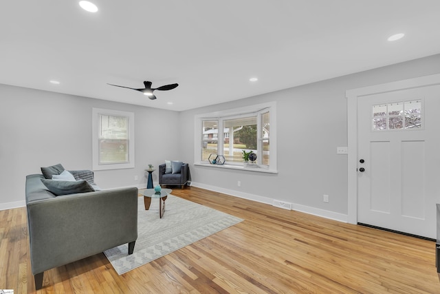 living area with light wood-type flooring, visible vents, and recessed lighting