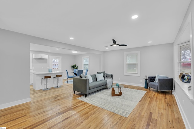 living room featuring recessed lighting, baseboards, and light wood finished floors