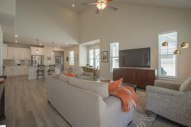 living room featuring recessed lighting, a healthy amount of sunlight, light wood-style floors, and ceiling fan