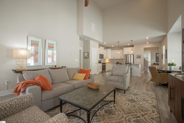 living room with stairway, recessed lighting, baseboards, and light wood-style floors