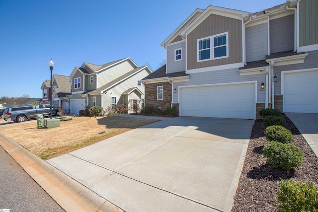 view of front of house with a garage, stone siding, board and batten siding, and driveway