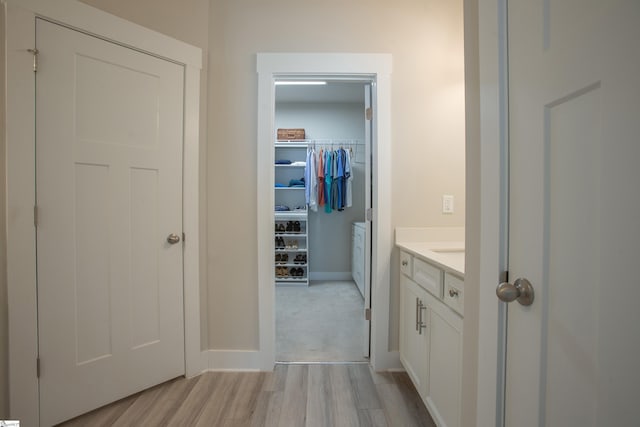 bathroom featuring vanity, wood finished floors, and baseboards