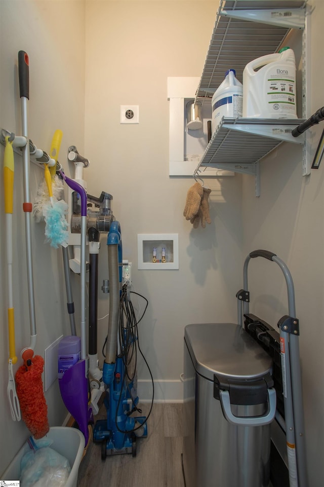 laundry area with hookup for a washing machine, wood finished floors, baseboards, and laundry area