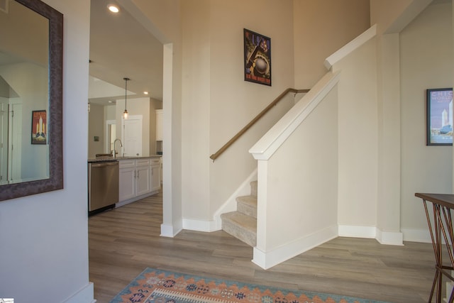 staircase featuring recessed lighting, wood finished floors, and baseboards