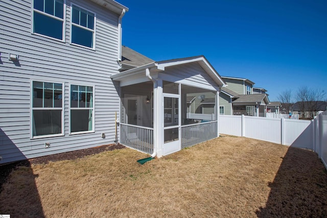 view of side of home featuring a yard, fence private yard, and a sunroom