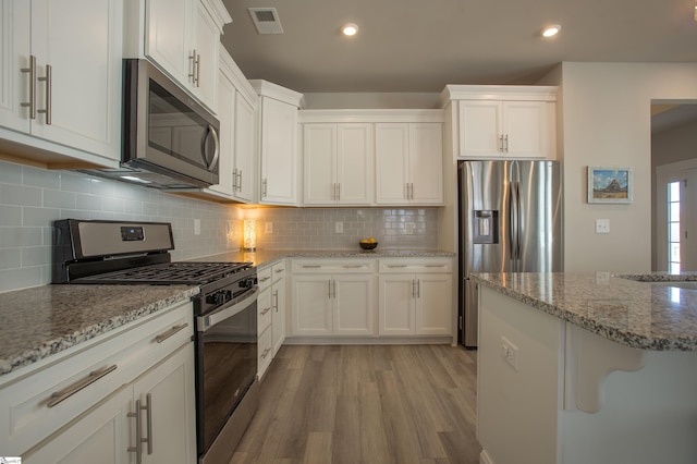 kitchen featuring white cabinetry, light wood-style floors, visible vents, and stainless steel appliances