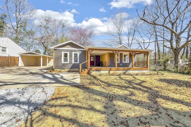 view of front of house with driveway, fence, covered porch, crawl space, and a carport